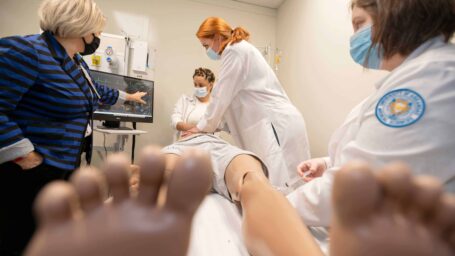Nursing students and faculty working with medical model